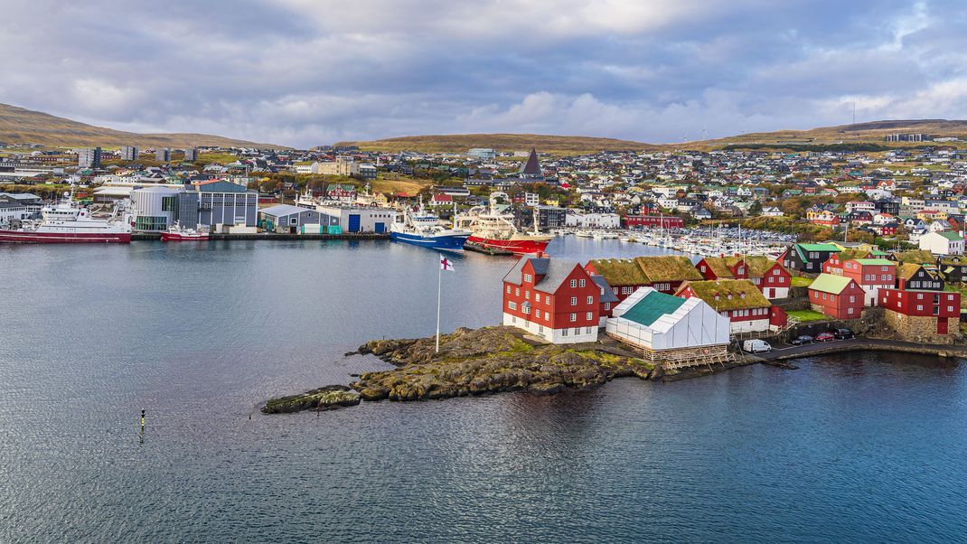 Färöer: Torshavn ist die Hauptstadt der Färöer-Inseln. Sie liegt auf der Hauptinsel Streymoys und hat gut 14.000 Einwohner:innen. Übersetzt heißt Färöer: „die Schafsinseln“. So zeigt das Wappen auch ein Schaf auf blauem Grund. Seit 2005 gelten die Färinger:innen als gleichberechtigte Nation innerhalb des dänischen Königreiches.