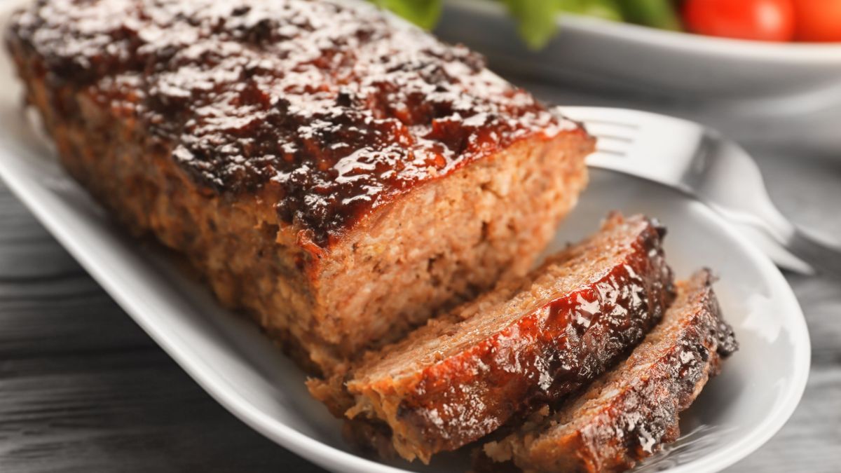 Plate with tasty baked turkey meatloaf on table, closeup