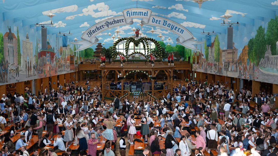Die ersten Besucher sitzen in einem Bierzelt.