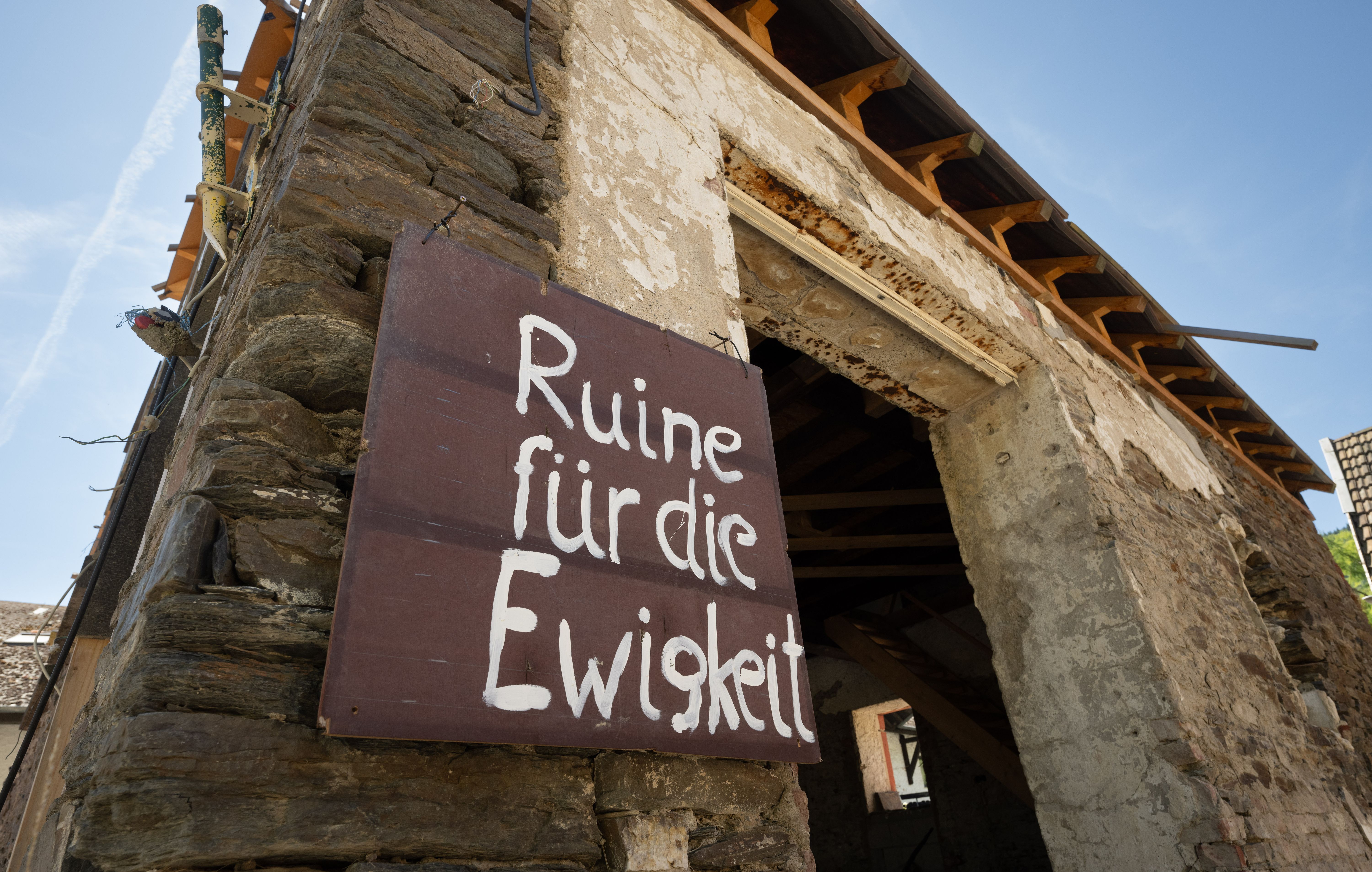 "Ruine für die Ewigkeit" steht auf einem Schild an einem zerstörten Haus im Weinort Mayschoß. Auch drei Jahre nach der Flutkatastrophe sind zahlreiche Häuser unbewohnbar.