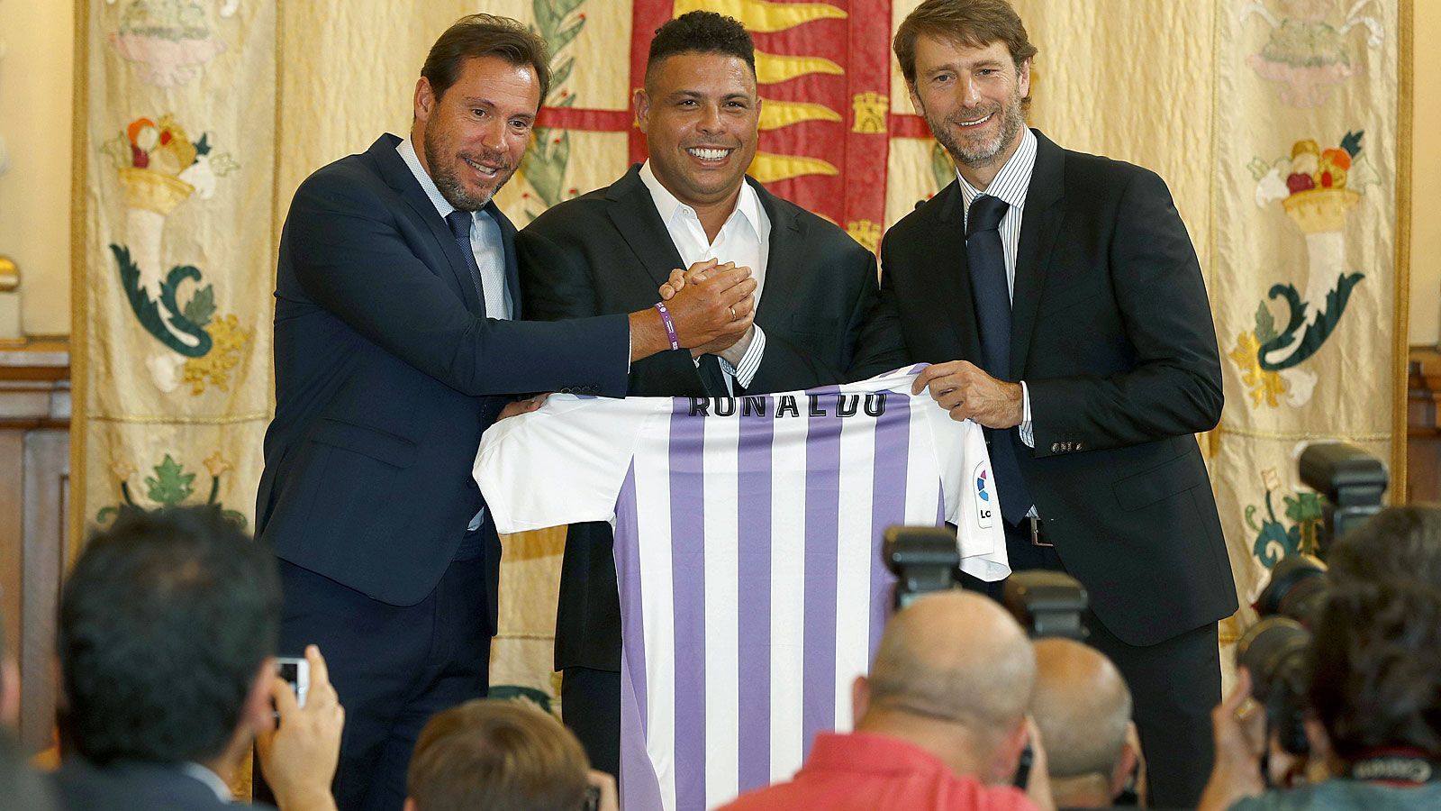 
                <strong>Real Valladolid (Spanien)</strong><br>
                Gerade erst war die Sommertransfer-Periode 2018 vorüber, da gelang dem spanischen Erstliga-Aufsteiger Real Valladolid Anfang September der eigentliche Coup. Der Klub präsentierte mit dem früheren Weltstar Ronaldo einen neuen Mehrheits-Eigentümer. "Wir wollen versuchen, so groß wie nur möglich zu werden", sagte der 42-jährige Brasilianer anlässlich der Klub-Übernahme und fügte an: "Ich bin davon überzeugt, dass es sehr schwer sein wird, gegen uns zu gewinnen, wenn wir Einheit an den Tag legen." Ronaldo soll das Investment um die 30 Millionen Euro gekostet haben - und sportlich läuft es für den Underdog in La Liga gut. Nach acht Spielen liegt Real Valladolid mit zwölf Punkten auf Platz 7 und ist der mit Abstand beste der drei diesjährigen Aufsteiger in Spaniens Oberhaus.
              