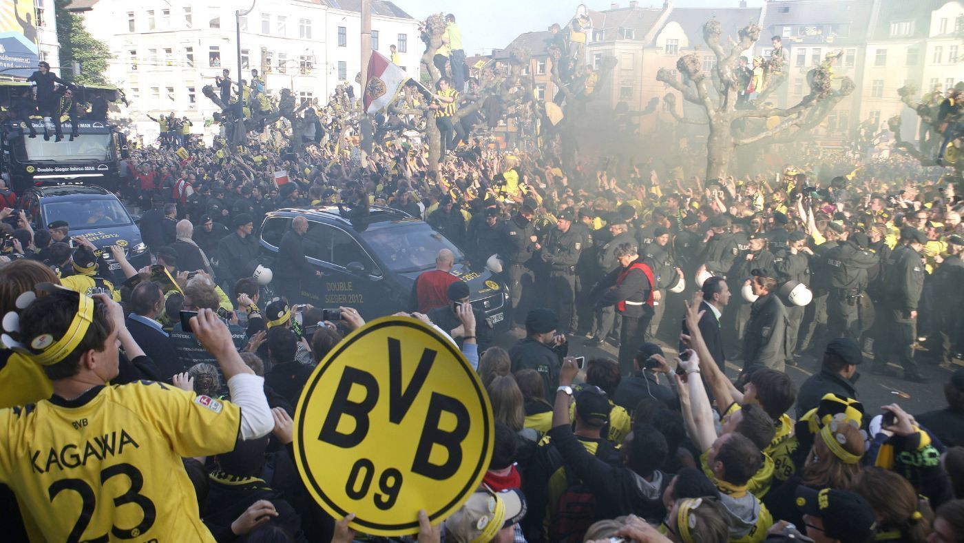 
                <strong>Marienplatz-Manko: Dortmund feiert einfach besser</strong><br>
                Zehn Jahre hintereinander Meisterfeier in München. Kein Wunder, dass der Marienplatz da scheinbar von Jahr zu Jahr leerer und leiser wird. Beim letzten Mal, dass der BVB mit der Schale über den Borsigplatz cruiste, hieß der US-Präsident noch Barack Obama und der Dortmund-Trainer Jürgen Klopp. Justin Bieber hatte noch seinen Teenie-Haarschnitt und Selena Gomez an seiner Seite. Lang ist's her. Zeit, dass eine Meisterfeier mal wieder im Ruhrgebiet steigt.
              