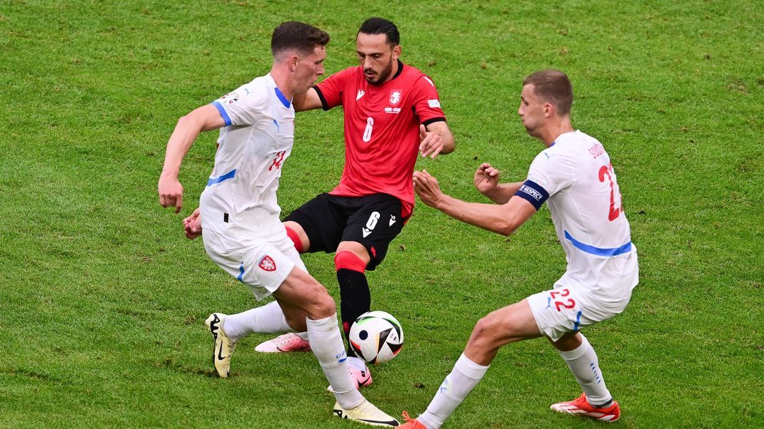 Georgiens Giorgi Kotschoraschwili (M) kämpft gegen Tschechiens Lukas Provod (l) und Tschechiens Tomas Soucek um den Ball.