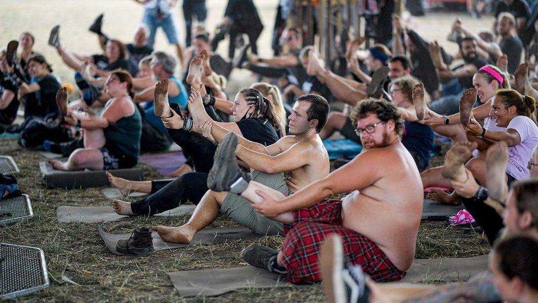 Sonnengruß mit Headbangen! Abwechselung vom Headbanging und dem Group Pogging findet ihr auf dem Wacken Open Air 2022 auch – es gibt Yoga-Veranstaltungen, die zum Mitmachen aufrufen.