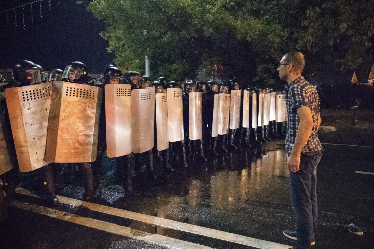 Ein Demonstrant stellt sich der Polizei entgegen.