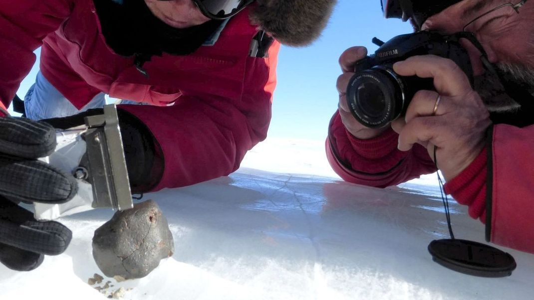 Überleben die Brocken aus dem All den heißen Ritt durch die Atmosphäre und erreichen den Erdboden, werden sie Meteoriten genannt. Hier ein Fund in der Antarktis. Dort sind sie besonders leicht zu finden, weil sie sich farblich vom Eis abheben.
