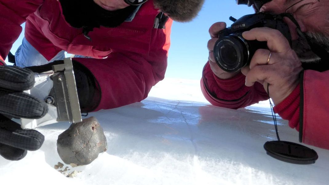 Überleben die Brocken aus dem All den heißen Ritt durch die Atmosphäre und erreichen den Erdboden, werden sie Meteoriten genannt. Hier ein Fund in der Antarktis. Dort sind sie besonders leicht zu finden, weil sie sich farblich vom Eis abheben.
