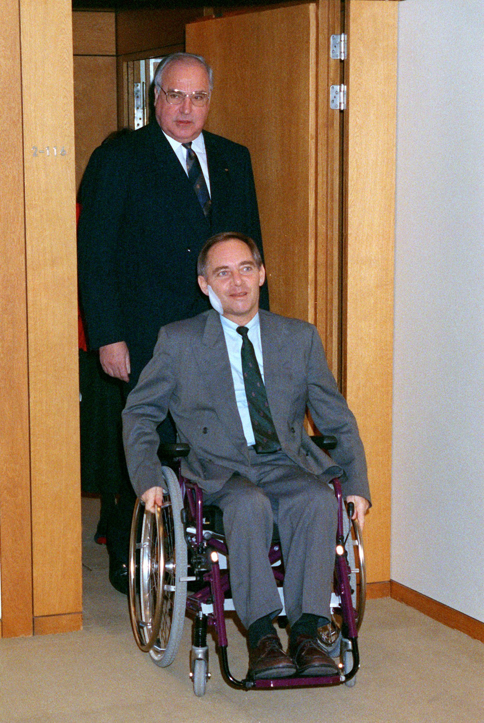 28. November 1990: Gefolgt von Bundeskanzler Helmut Kohl ist der damalige Innenminister Wolfgang Schäuble auf dem&nbsp; Weg zu seiner ersten Kabinettssitzung in Bonn nach dem Attentat.