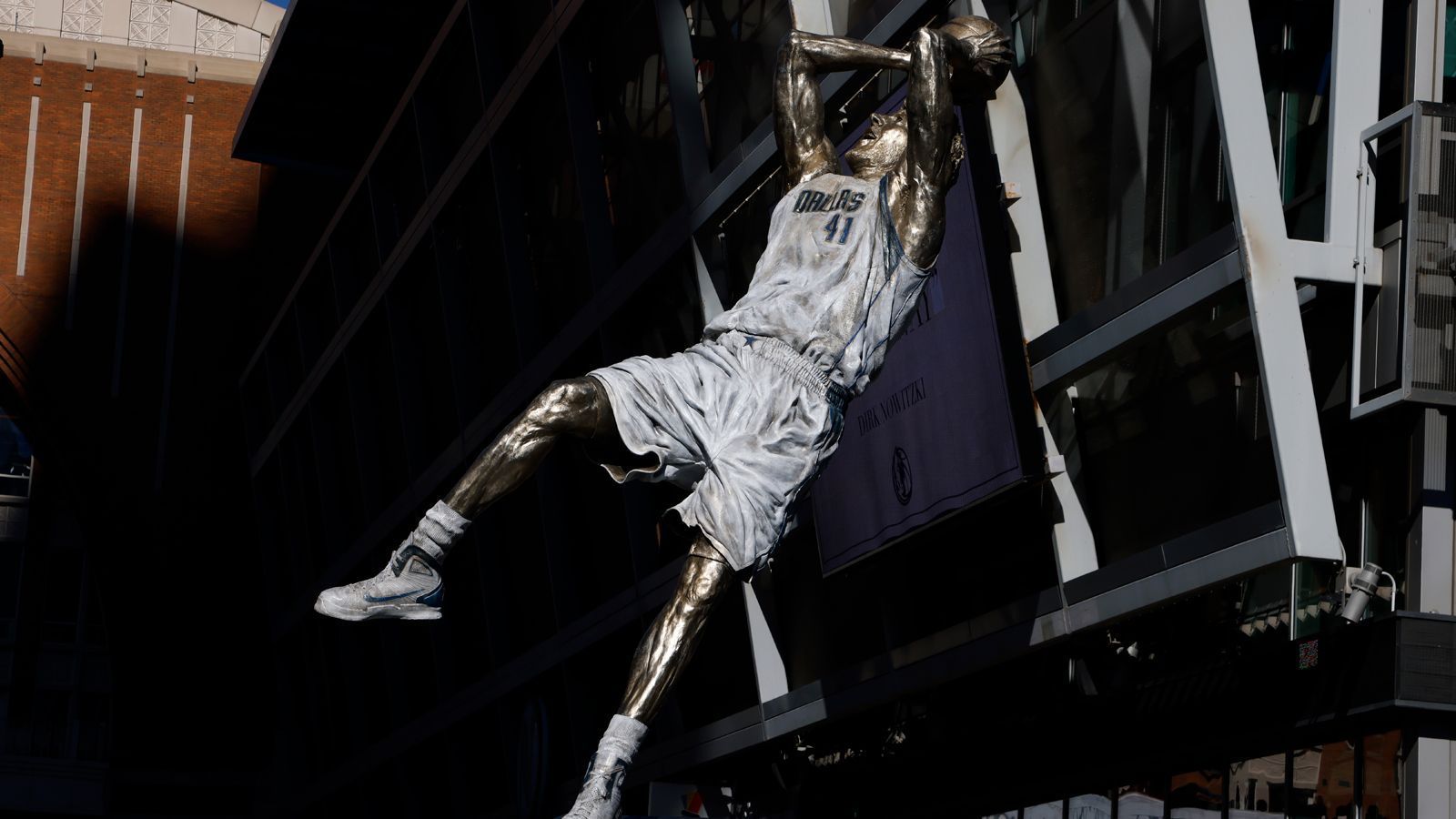 
                <strong>Nowitzki auch in der Halle verewigt</strong><br>
                Vor dem American Airlines Center, der Heim-Arena der Mavericks, wird ab jetzt Nowitzki mit dem "One Leg Fadeaway" die Basketball-Fans begrüßen. In der Halle selbst ist Nowitzkis "Fadeaway" als Silhouette auf dem Hallenparkett verewigt. Mit seiner eigenen Statue bekommt der Würzburger jetzt die nächste Ehrung für seine große NBA-Karriere.
              
