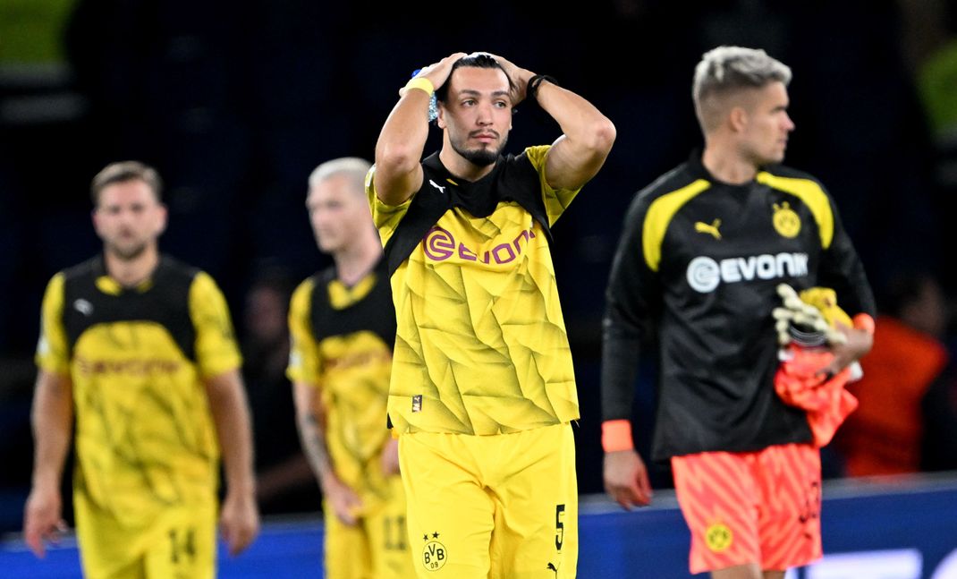 Dortmunds Ramy Bensebaini (M) fasst sich nach dem Spiel an den Kopf. Der BVB verliert in Paris.