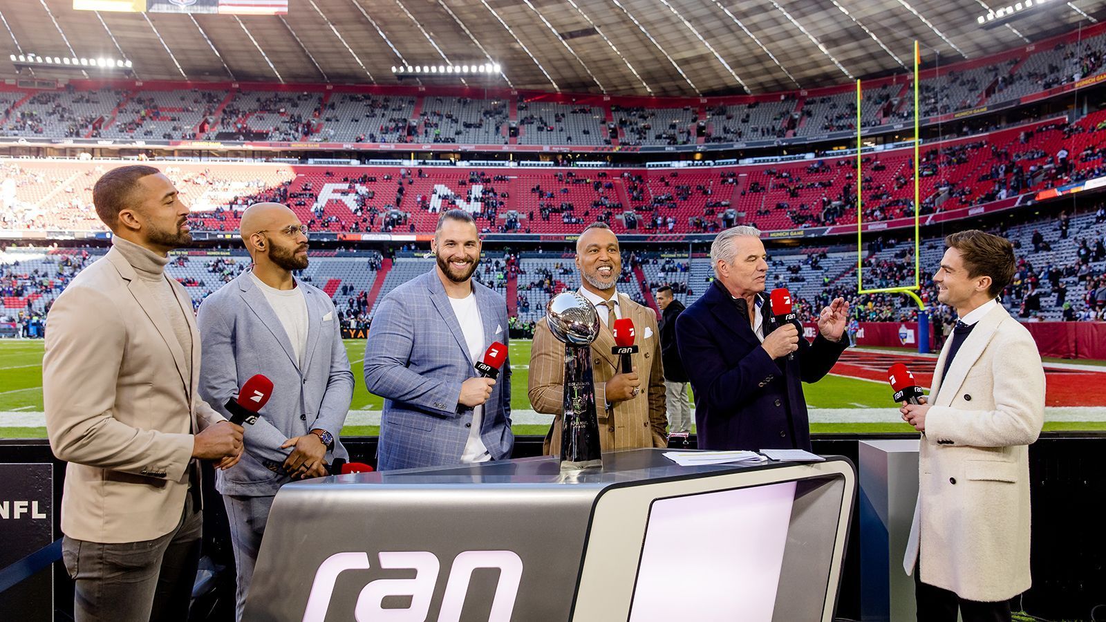 
                <strong>ran-Crew im Stadion</strong><br>
                Die ran-Crew im Stadion von links nach rechts: Mark Nzeocha, Kasim Edebali, Björn Werner, Patrick Esume, Jan Stecker und Max Zielke. 
              