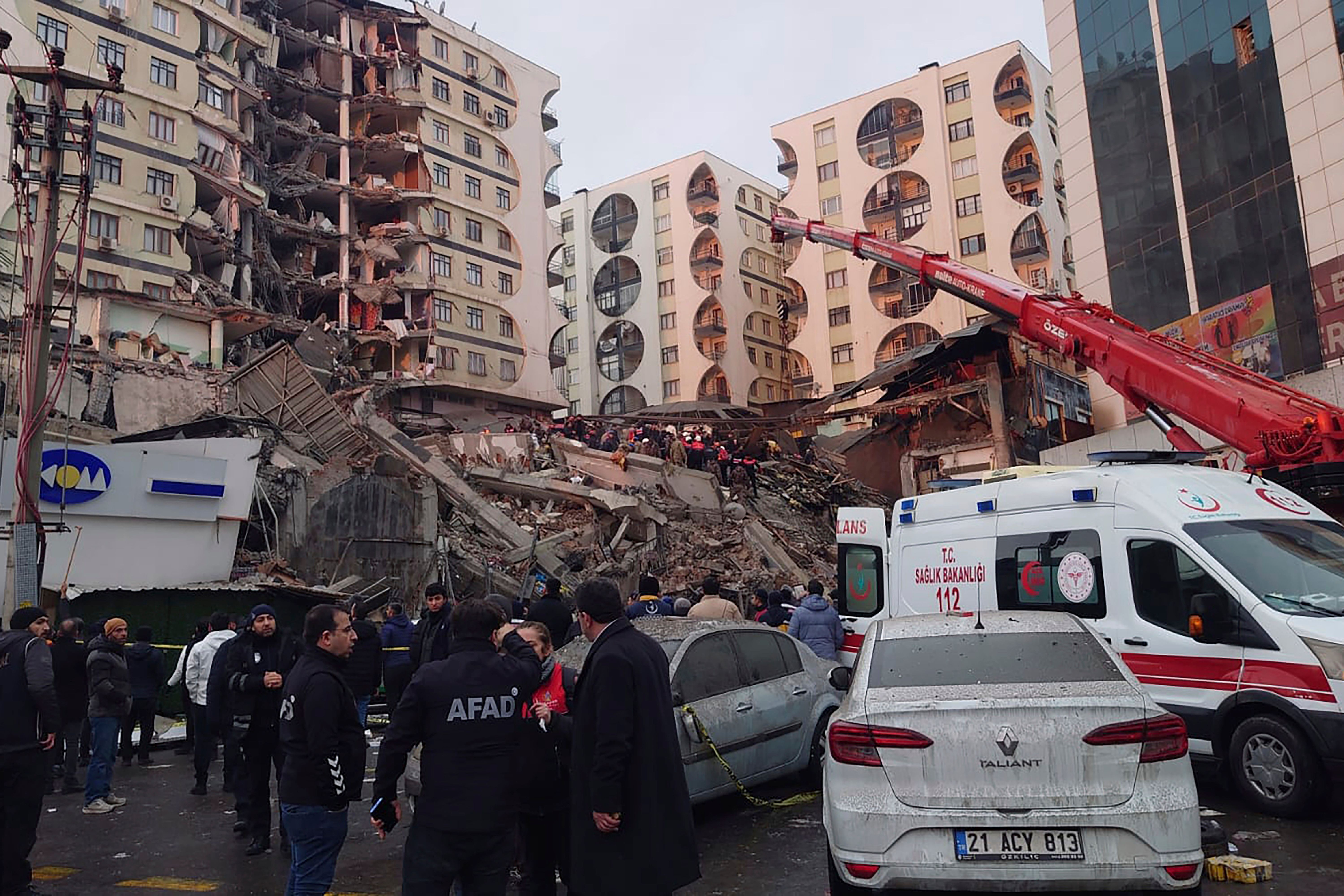 Rettungskräfte und medizinische Teams versuchen verschüttete Bewohner in einem eingestürzten Gebäude zu erreichen. 