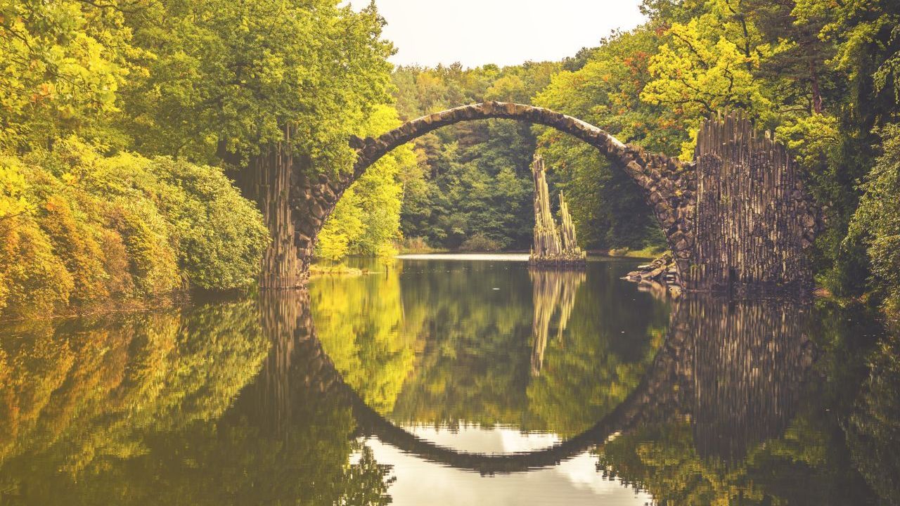 Kein klassischer Badesee, aber mittlerweile eine Instagram-Berühmtheit, die einem Märchen der Gebrüder Grimm entsprungen sein könnte: die "Teufelsbrücke" über dem Rakotzsee bei Görlitz in Sachsen. Früher glaubten die Menschen, dass nur der Teufel höchstpersönlich die im Jahr 1863 auf Basaltsäulen erbaute Brücke überschreiten könne. Heute beweisen Touristen aus aller Welt das Gegenteil.