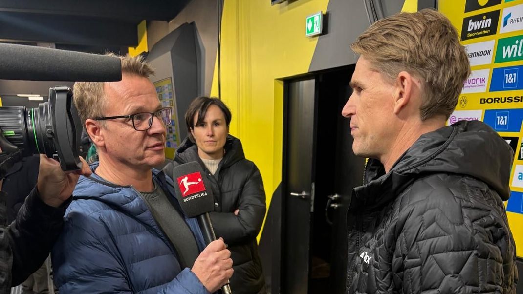 Bayern-Sportdirektor Christoph Freund (r.) steht ran-Repoter Martin Volkmar nach dem Spiel in Dortmund Rede und Antwort