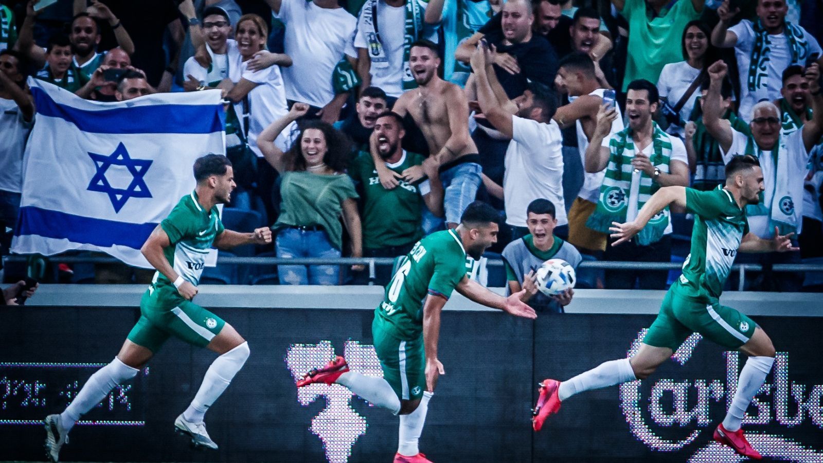 
                <strong>Maccabi Haifa feiert Titel vor ausverkauftem Haus</strong><br>
                Was in Deutschland seit März 2020 undenkbar ist, ist in Israel nun wieder Realität: ein restlos ausverkauftes Stadion, so gesehen in Haifa am letzten Spieltag der 1. Liga Israels. Es ist wie aus einem Land vor unserer Zeit: jubelnde Fans, keine Schutzmasken, keine Abstände. Am Ende feierten die Maccabi-Fans den Meistertitel. ran.de zeigt Bilder von der Party des neuen israelischen Meisters.
              