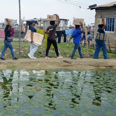 26. November 2024, Nigeria, Lagos: Freiwillige tragen Lebensmittel, die von der Lagos Food Bank Initiative an die Bewohner des Oworonshoki Slums verteilt werden. 