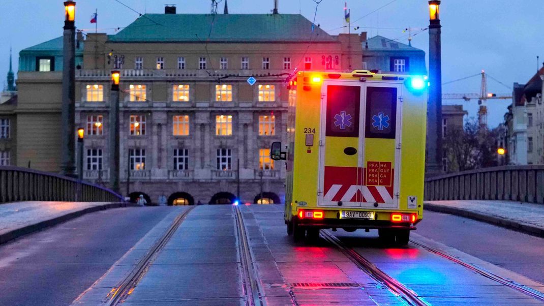 Ein Krankenwagen fährt in Richtung des Gebäudes der Philosophischen Fakultät der Karls-Universität.