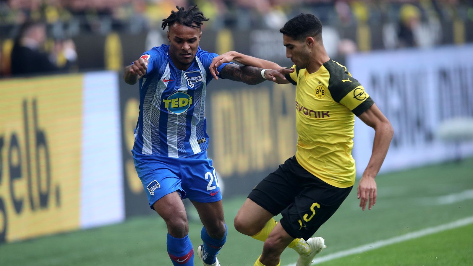 
                <strong>Achraf Hakimi</strong><br>
                Der Offensivste in der Abwehrkette mit unglaublich viel Zug nach vorne. Leitet im Zusammenspiel mit Reus die gefährlichsten BVB-Chancen ein. Taucht auch selbst immer wieder im Strafraum auf. Bereits in der 3. Minute bekommt er nach Vorlage von Götze im 16er jedoch nicht genug Druck hinter den Ball, das hätte die Führung sein können. In der 16. Minute verfehlt ein Distanzschuss von der Strafraumgrenze den rechten Pfosten nur knapp. Strahlt trotz einer frühen Gelben Karte auch defensiv Ruhe aus. Erstickt kurz nach dem unglücklichen Ausgleich einen weiteren Berliner Konter im Keim. Bereits mit einem Zuckerpass in den Strafraum das 2:1 ein.ran-Note: 1.
              