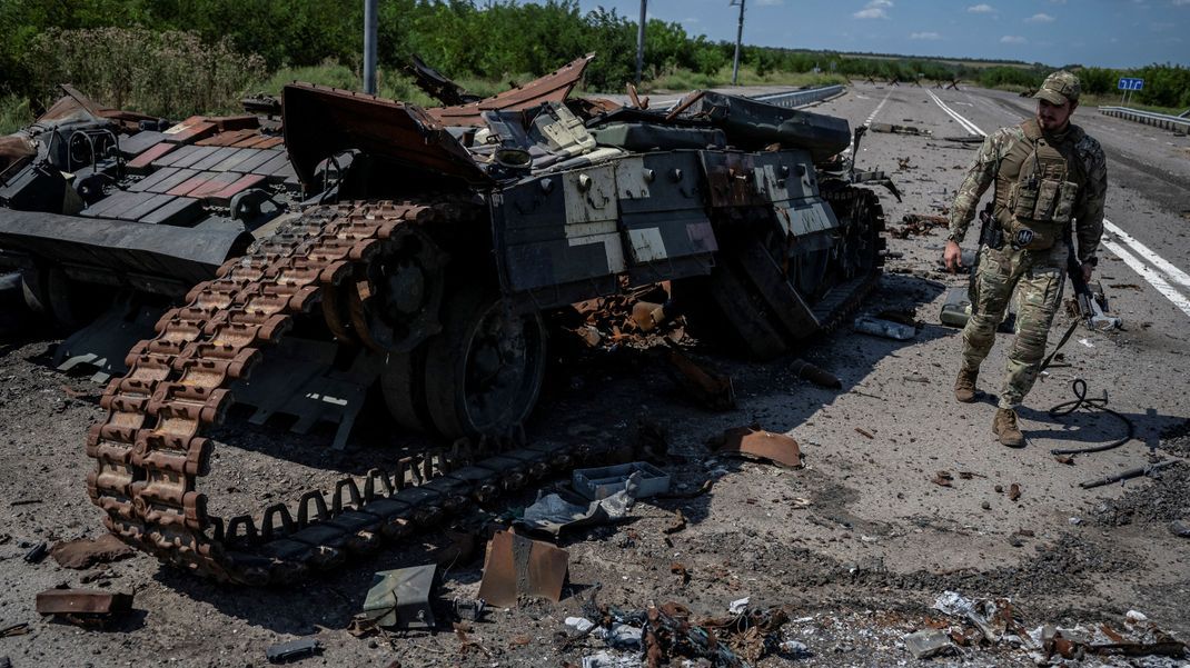 Ein ukrainischer Soldat neben einem zerstörten russischen Panzer in der eroberten Stadt Robotyne.
