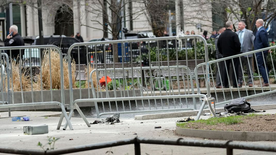 19.04.2024: Mitarbeiter der New Yorker Polizei und der Feuerwehr inspizieren die Stelle im Collect Pond Park, an der sich ein Mann vor dem Strafgericht in Manhattan angezündet hat. 