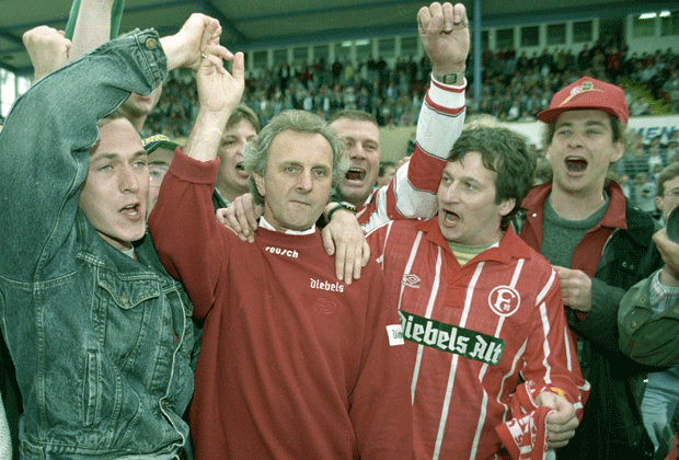 
                <strong>Fortuna Düsseldorf (1995)</strong><br>
                Schon ein Jahr später macht Fortuna Düsseldorf das Kunststück der Löwen nach. Unter Cheftrainer Alex Ristic (Mitte) gelingt den Rheinländern 1995 der Durchmarsch.
              
