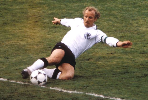 
                <strong>WM 1978</strong><br>
                Bei Berti Vogts blieben die weißen Stutzen nur selten auch nach dem Schlusspiff weiß. Der Defensivspezialist grätschte nach fast jedem Ball und gab dem weißen Trikot bei der WM 1978 damit auch einige grüne Flecken.
              
