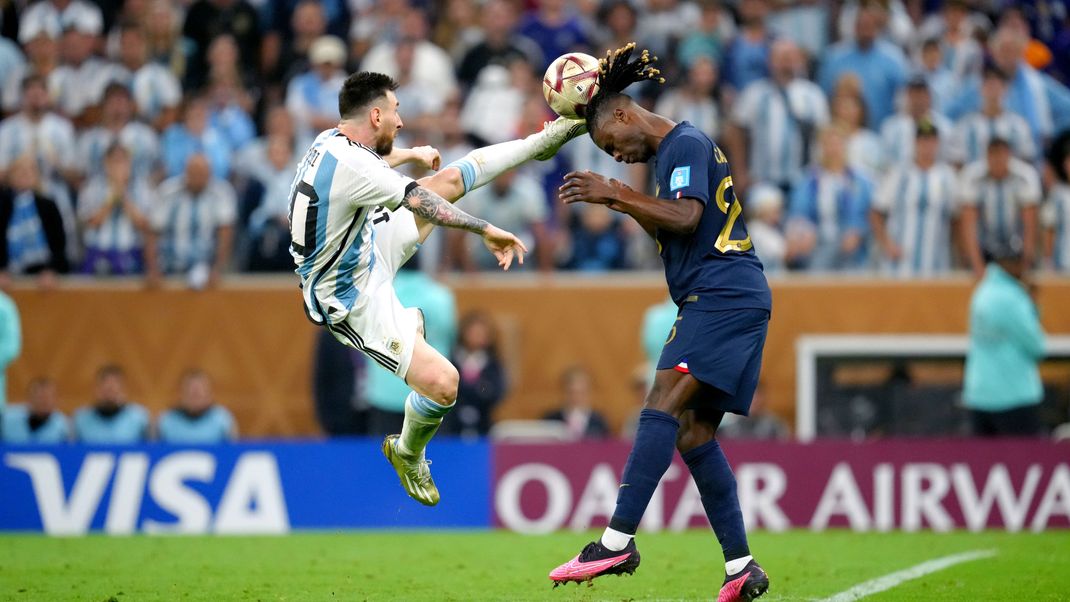 Argentiniens Lionel Messi (l) und Frankreichs Eduardo Camavinga kämpfen um den Ball.