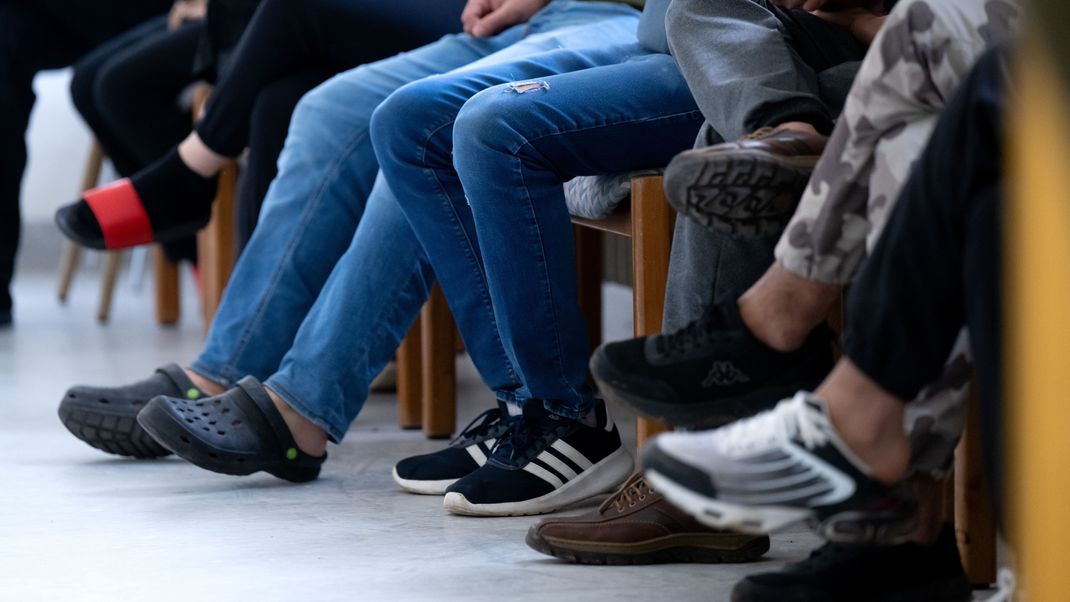 Asylbewerber warten im Ankerzentrum auf die Ausgabe von bayerischen Bezahlkarten. 