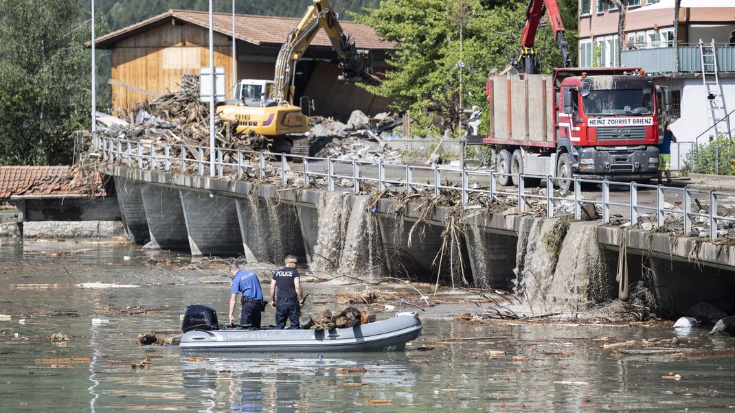 Polizisten ziehen nach dem Unwetter Schwemmholz aus dem Brienzersee.