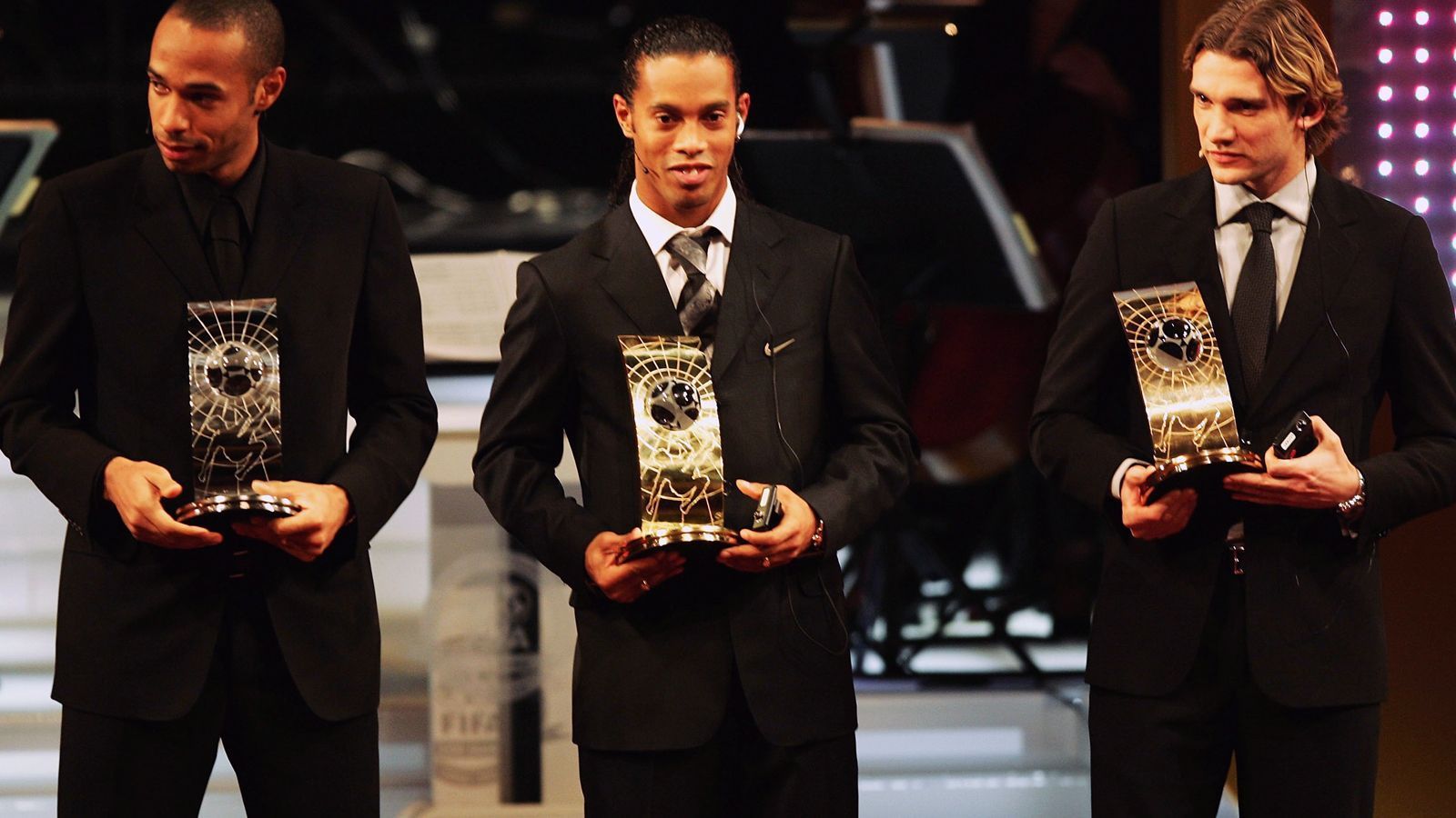
                <strong>Ronaldinho (2004)</strong><br>
                Auch 2004 ging der Titel des Weltfußballers erneut nach Spanien, aber nach Barcelona statt Madrid. Der Brasilianer Ronaldinho (Mi.) von Barca landete vor Thierry Henry (li.) und Andrey Shevchenko vom AC Mailand (re.) auf Platz 1 bei der FIFA-Weltfußballerwahl.
              