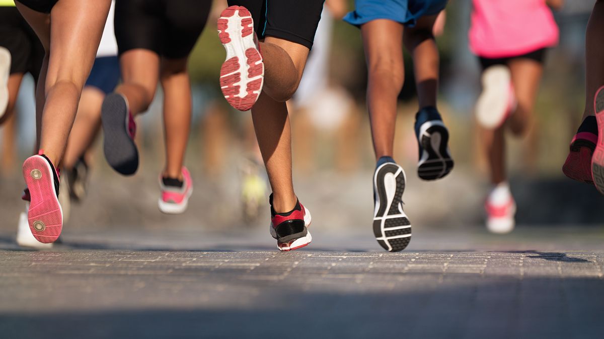 Running children, young athletes run in a kids run race,running on city road detail on legs,running in the light of morning