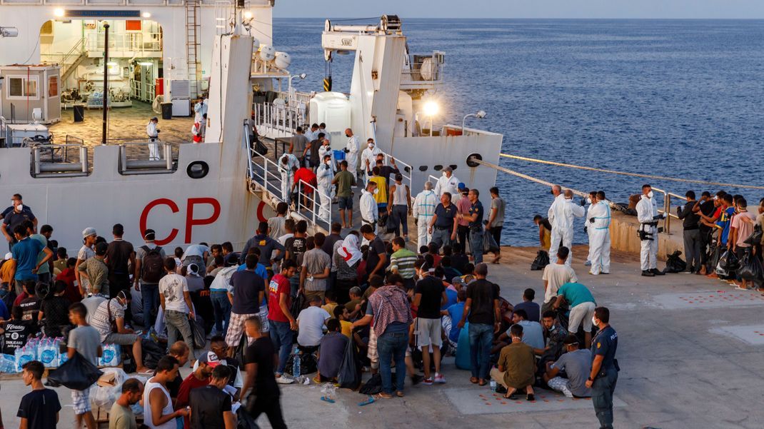 Migranten warten an Bord eines Schiffes der italienischen Küstenwache auf der sizilianischen Insel Lampedusa.