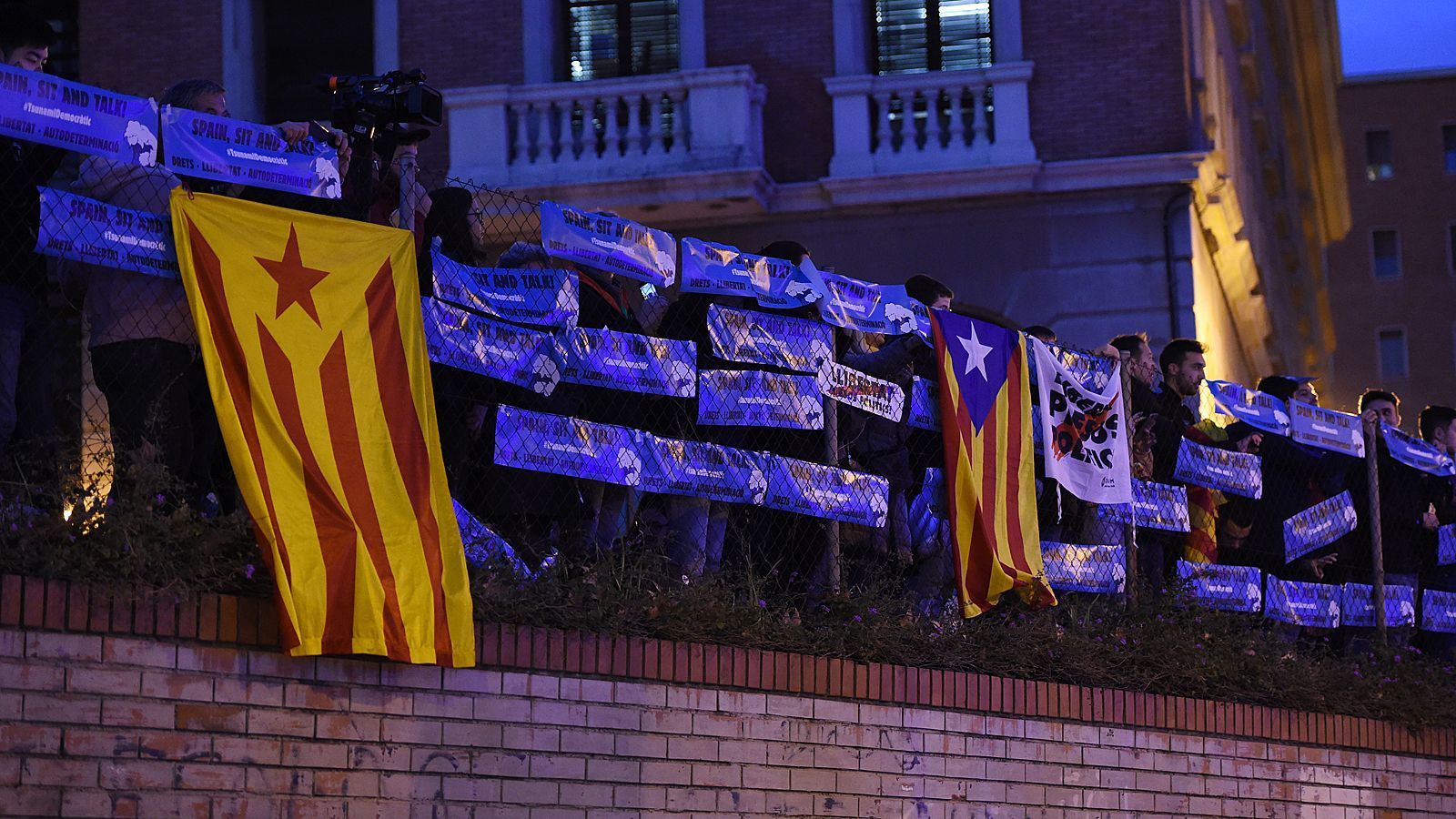 
                <strong>Politische Statements auf dem Weg ins Stadion</strong><br>
                Wegen politischer Unruhen wurde der Clasico von Ende Oktober auf Mitte Dezember verlegt. Auch an diesem vorweihnachtlichen Abend lassen es sich zahlreiche Katalanen jedoch nicht nehmen, die Bühne für ihre Statements zu nutzen. Der Weg der Busse ins Stadion ist geschmückt mit zahlreichen Plakaten und Bannern.
              