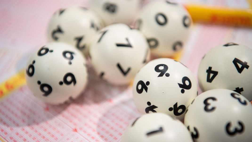 Lotto-Kugeln liegen auf einem Lottoschein.