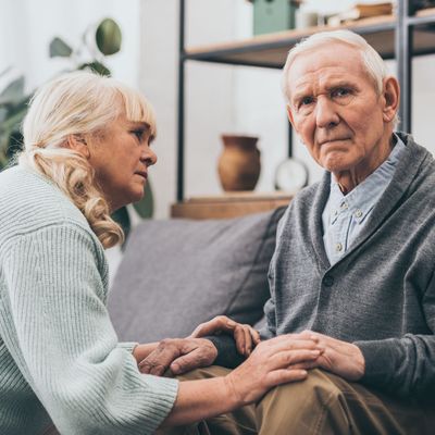 retired wife looking at senior husband in living room