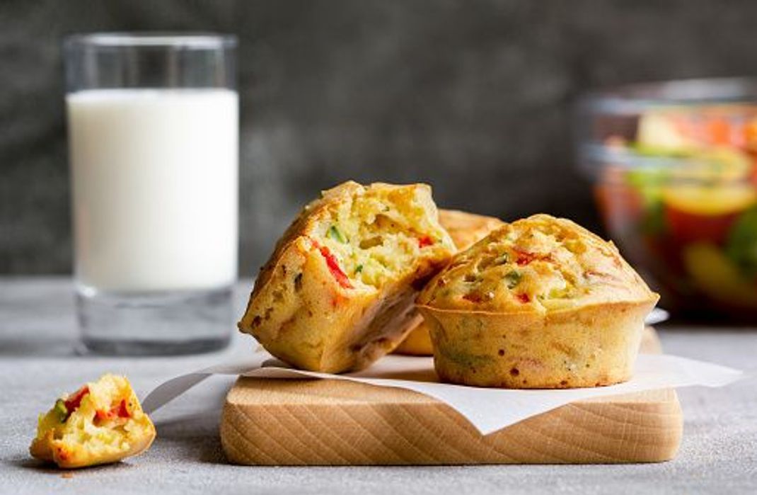 Vegetables muffins with cheese on a cutting board. Salad and milk on a grey background. Healthy vegetarian food, meal, dinner or snack. Close up.