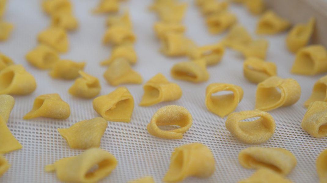 Der Mythos um die Tortellini-Form: In Bologna soll den Koch der Bauchnabel der Göttin Venus zur Pasta-Form inspiriert haben, in Modena war es jener der italienischen Fürstin Lucrezia Borgia. Wie auch immer - unten im Video siehst du, wie du die Bauchnabel-Form selber hinbekommst.