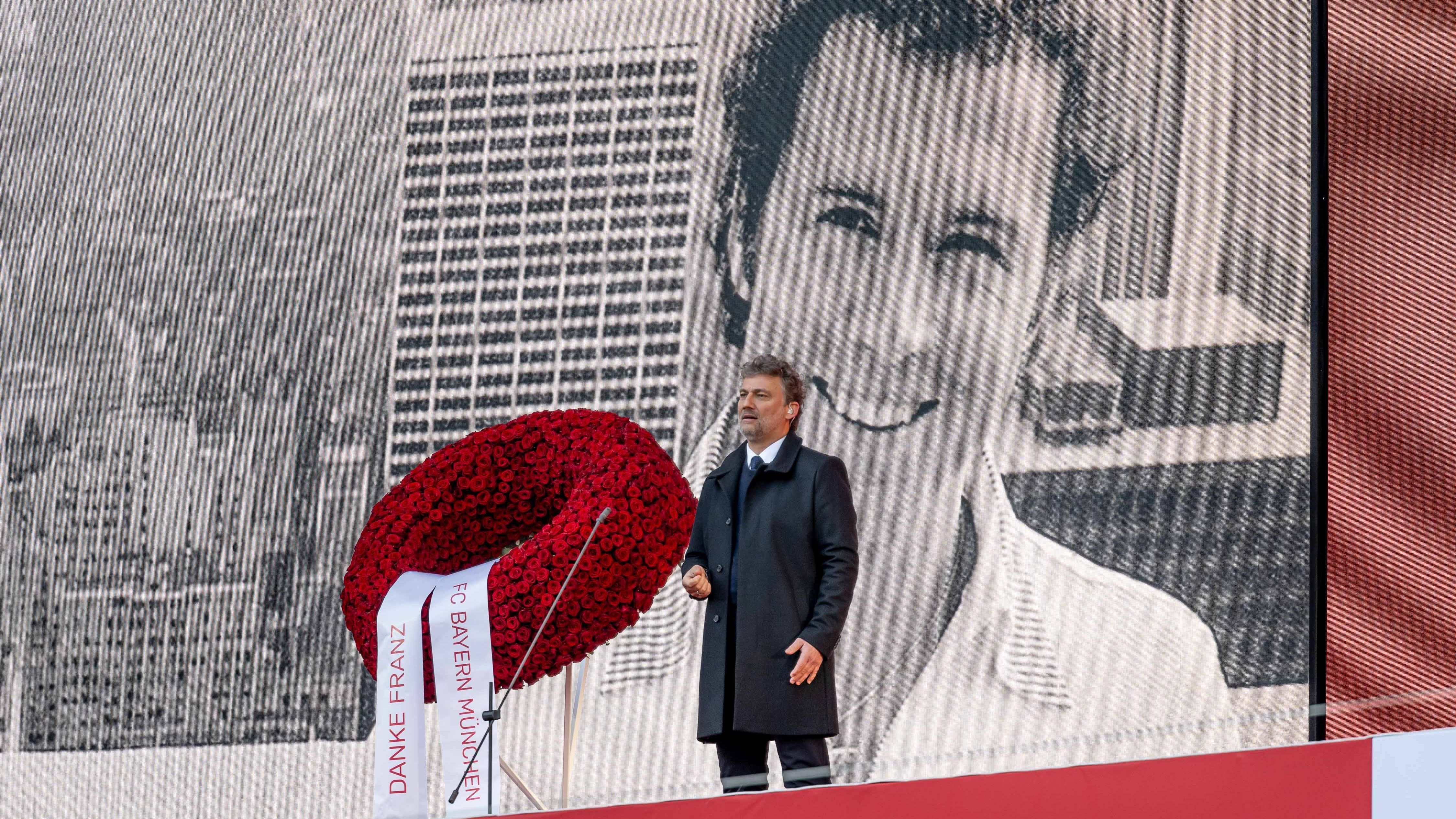 <strong>Jonas Kaufmann verabschiedet Beckenbauer musikalisch</strong><br>Star-Tenor Jonas Kaufmann steht nach der Begrüßungsrede von Bayern-Präsident Herbert Hainer auf der Bühne und singt die italienische Version von "Time to say goodbye". Hinter ihm ist ein Foto von Franz Beckenbauer zu sehen, das den jungen "Kaiser" in New York zeigt. Dort spielte er nach seiner großen Zeit bei den Bayern für Cosmos New York zusammen mit Pele.