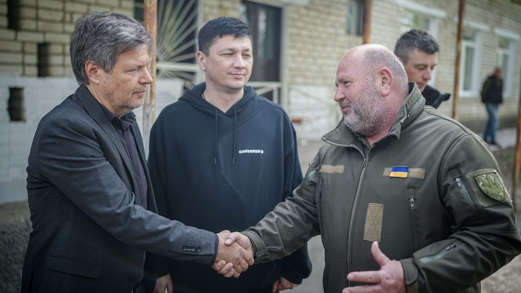 Robert Habeck (Bündnis 90/Die Grünen), Bundesminister für Wirtschaft und Klimaschutz, verabschiedet sich nach dem Besuch eines Krankenhauses von Wladislaw Dimitriw (r), Chef der lokalen Militärverwaltung, und Witalij Kim, Gouverneur der Region Mykolajiw. 