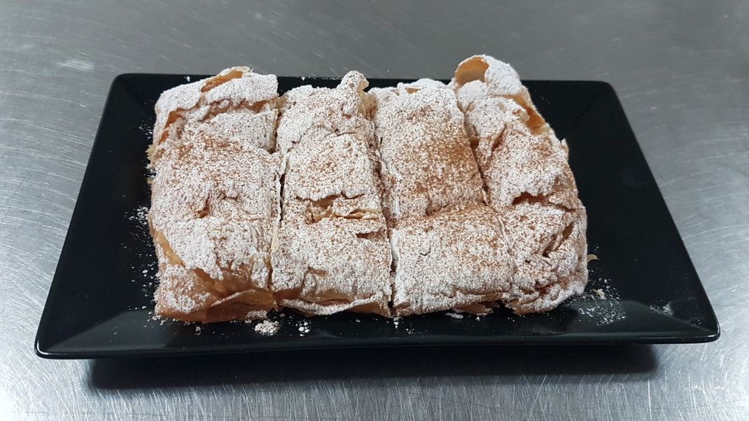 Bougatsa ist ein griechisches Gebäck aus Blätterteig. Neben der süßen Füllung mit Creme oder Grieß-Pudding gibt es auch salzige Varianten mit Käse-, Hackfleisch- oder Spinat-Füllung. Bei uns landet heute die süße Bougatsa auf dem Teller.