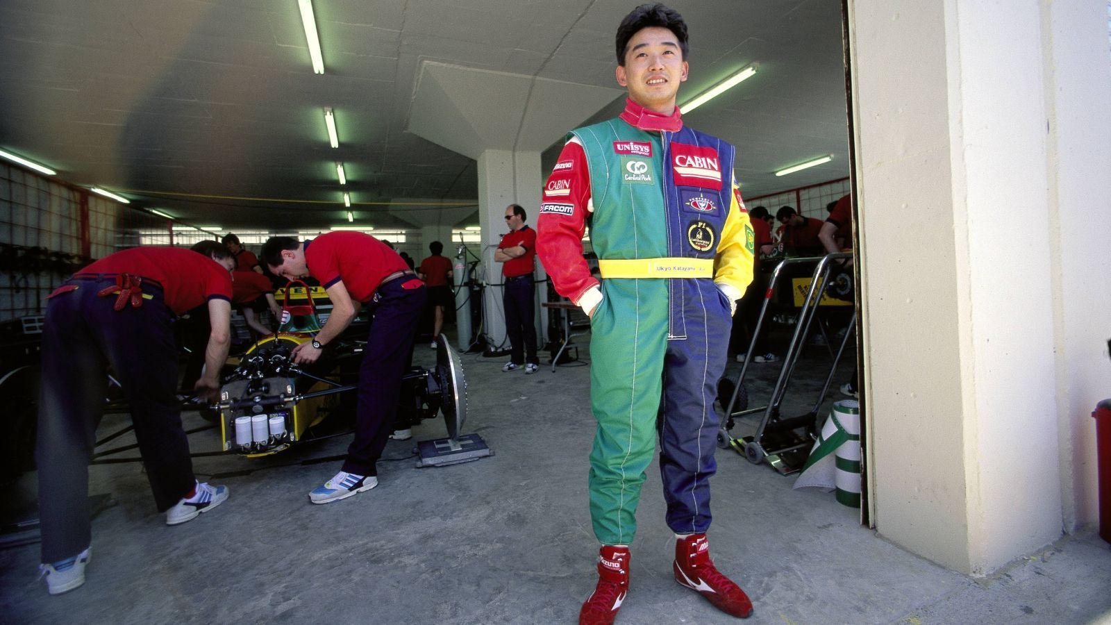 
                <strong>Ukyo Katayama</strong><br>
                Der Japaner gehört zu den Fahrern mit Kultstatus. Bei 95 Rennen stand er am Start, 26 Mal schaffte er es nicht bis in das Ziel. Sechs Kollisionen, neun Unfälle, elf Dreher, stets wurde sein Rennen auf andere Art und Weise beendet. Vor allem sein Fahrstil war spektakulär. Für eine einfache Kurve brauchte er mehrere Lenkeinschläge. Wie das funktioniert, haben selbst seine Kollegen nie begriffen. Nachdem bei ihm 1994 ein Tumor im Rücken entdeckt wurde, hatte er fortan starke Schmerzen beim Fahren und verunfallte noch häufiger. Alleine in der Saison 1995 schied er acht Mal aus. Seinerzeit hätte er Teamkollege von Michael Schumacher bei Benetton werden sollen, der Tumor verhinderte dies jedoch.
              