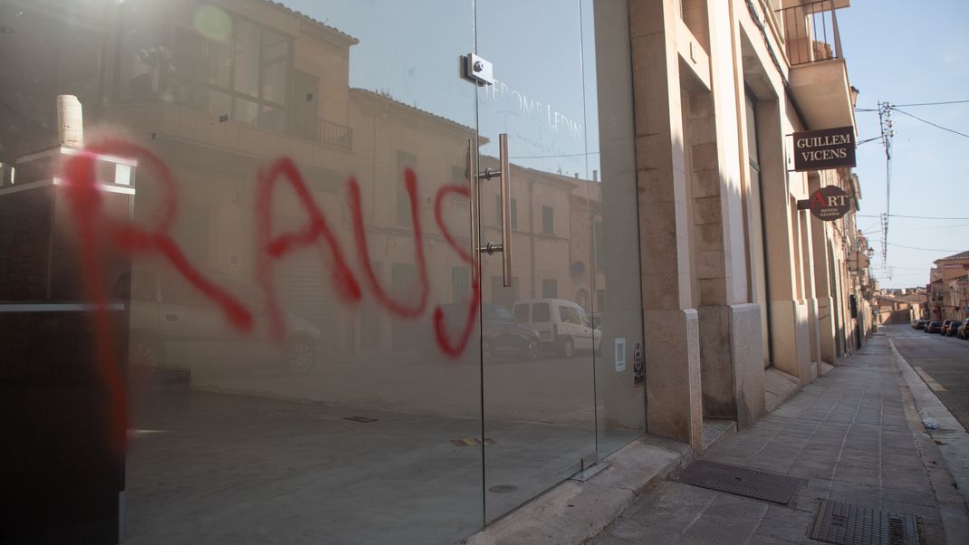 Ein Graffiti mit der Aufschrift "Raus" ist am Fenster eines Immobilienbüros in Santanyi auf Mallorca zu sehen. 