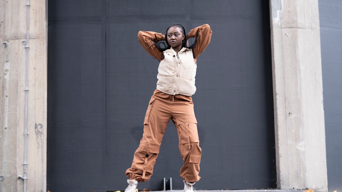 Young woman in sports clothing dancing in city