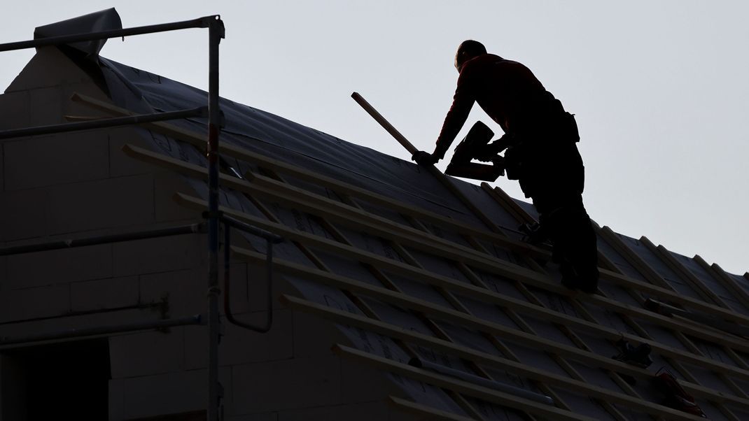 Archivbild: Ein Dachdecker arbeitet auf einem Einfamilienhaus am Leipziger Stadtrand. Der Handwerkermangel in Deutschland hat im vergangenen Jahr laut einer Studie ein neues Rekordniveau erricht.