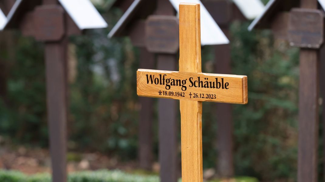 Ein Kreuz kennzeichnet am Rande der Trauerfeier für Wolfgang Schäuble die Grabstätte auf dem Friedhof. 