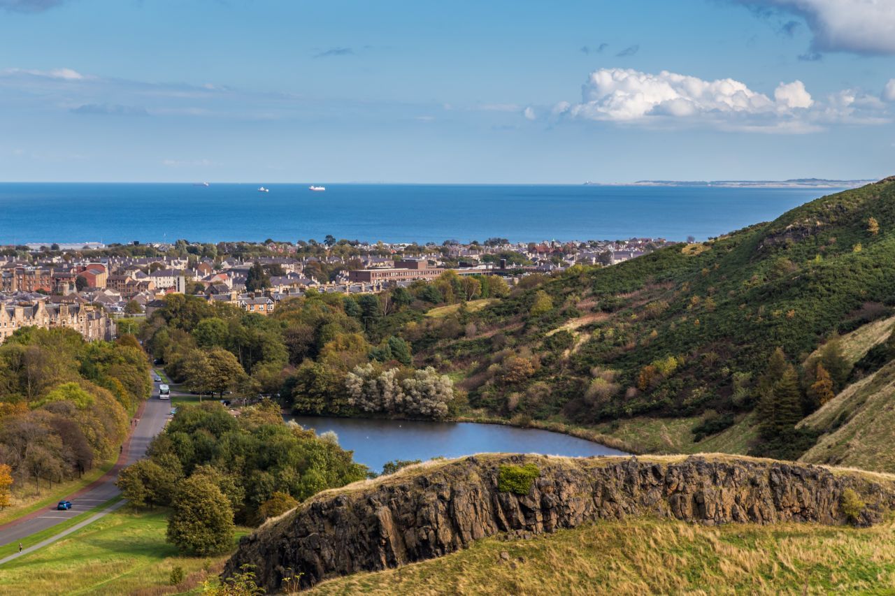 Als wäre ein Stück Schottisches Hochland nach Edinburgh verpflanzt worden: Der Holyrood Park verzaubert Natur-Fans auf 260 Hektar mit kleinen Seen, zerklüfteten Felsen - und einem stattlichen Berg. Der 251 Meter hohe Arthur's Seat war einst ein Feuer spuckendes Ungeheuer, heute genießt man an den grünen Hängen des erloschenen Vulkans den Sonnenuntergang. An den Park grenzt der Holyrood Palace, die offizielle Residenz der brit