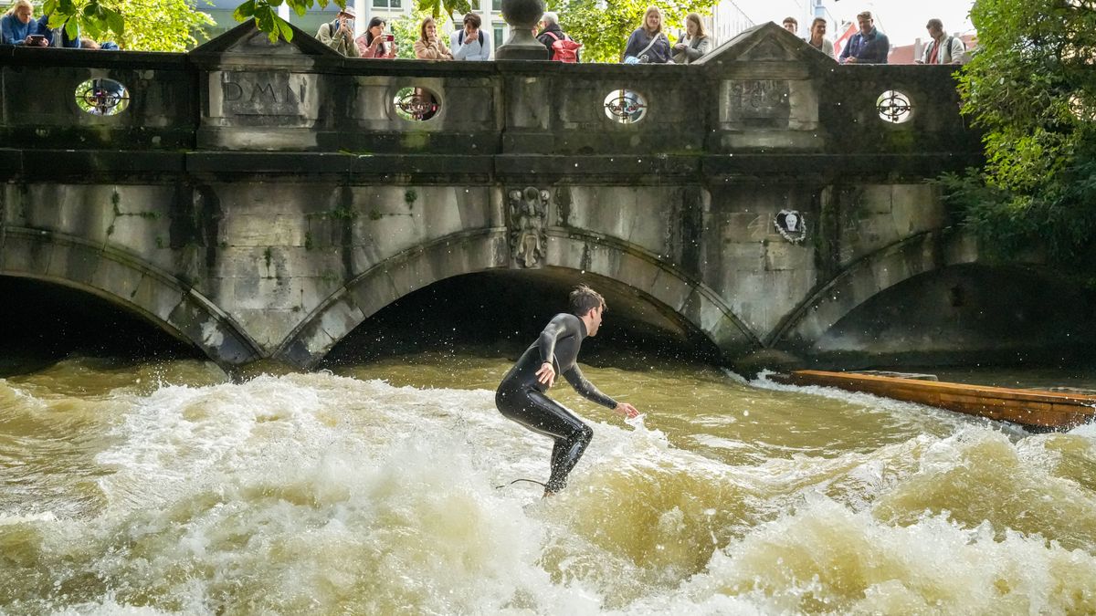 Surfer im Eisbach, Englischer Garten, München. Die Eisbachwelle, eine große Flusswelle mitten in der Stadt, ist eine Top-Attraktion in München. *** Surfer at Eisbach, English Garden, Munich the Eis...