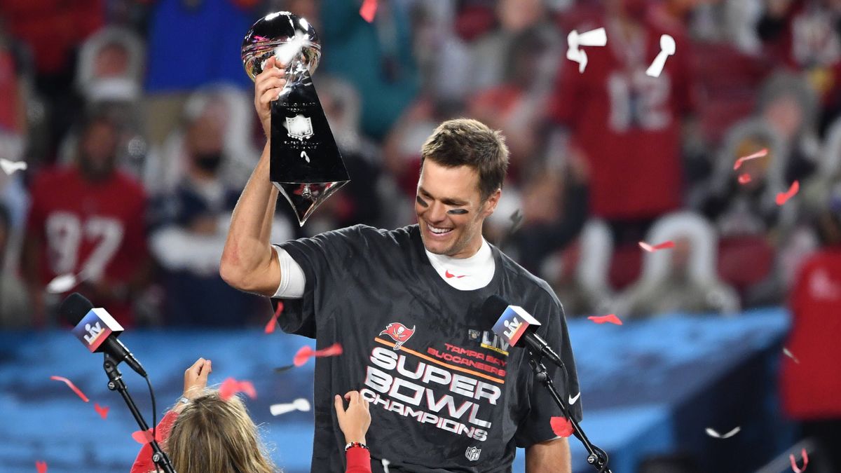 Tampa Bay Buccaneers quarterback Tom Brady looks at one of his children as he holds the Vince Lombardi Trophy after the Buccaneers defeated the Kansas City Chiefs 31-9 to win Super Bowl LV at Raymo...