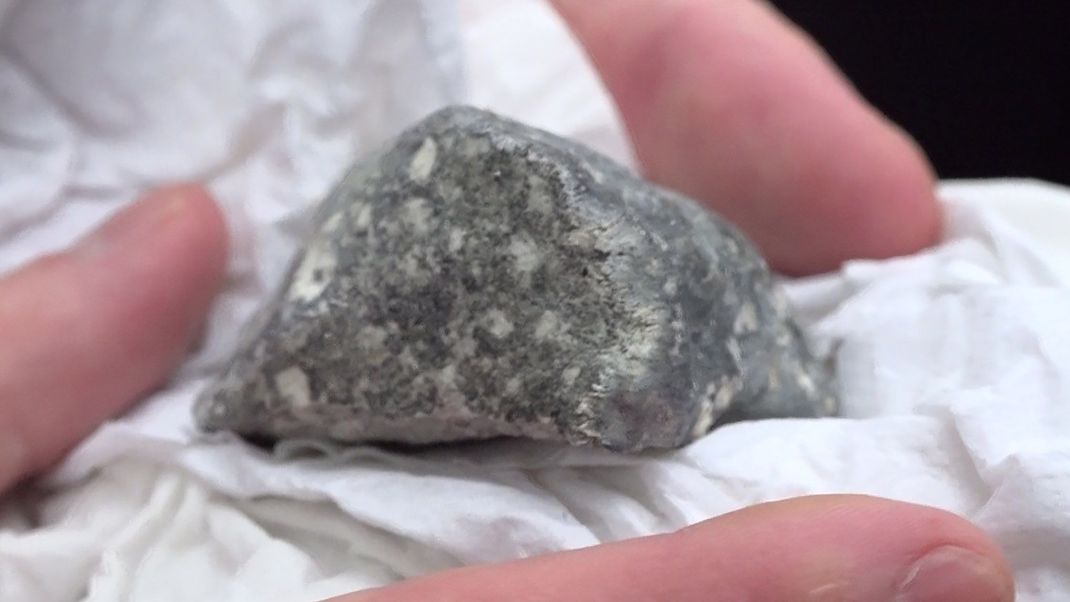 Ein mutmaßliches Meteoritenteil liegt in einem Papiertaschentuch. Das Bruchstück wurde von vier polnischen Meteoritensuchern auf einem Feld bei Ribbeck gefunden. 