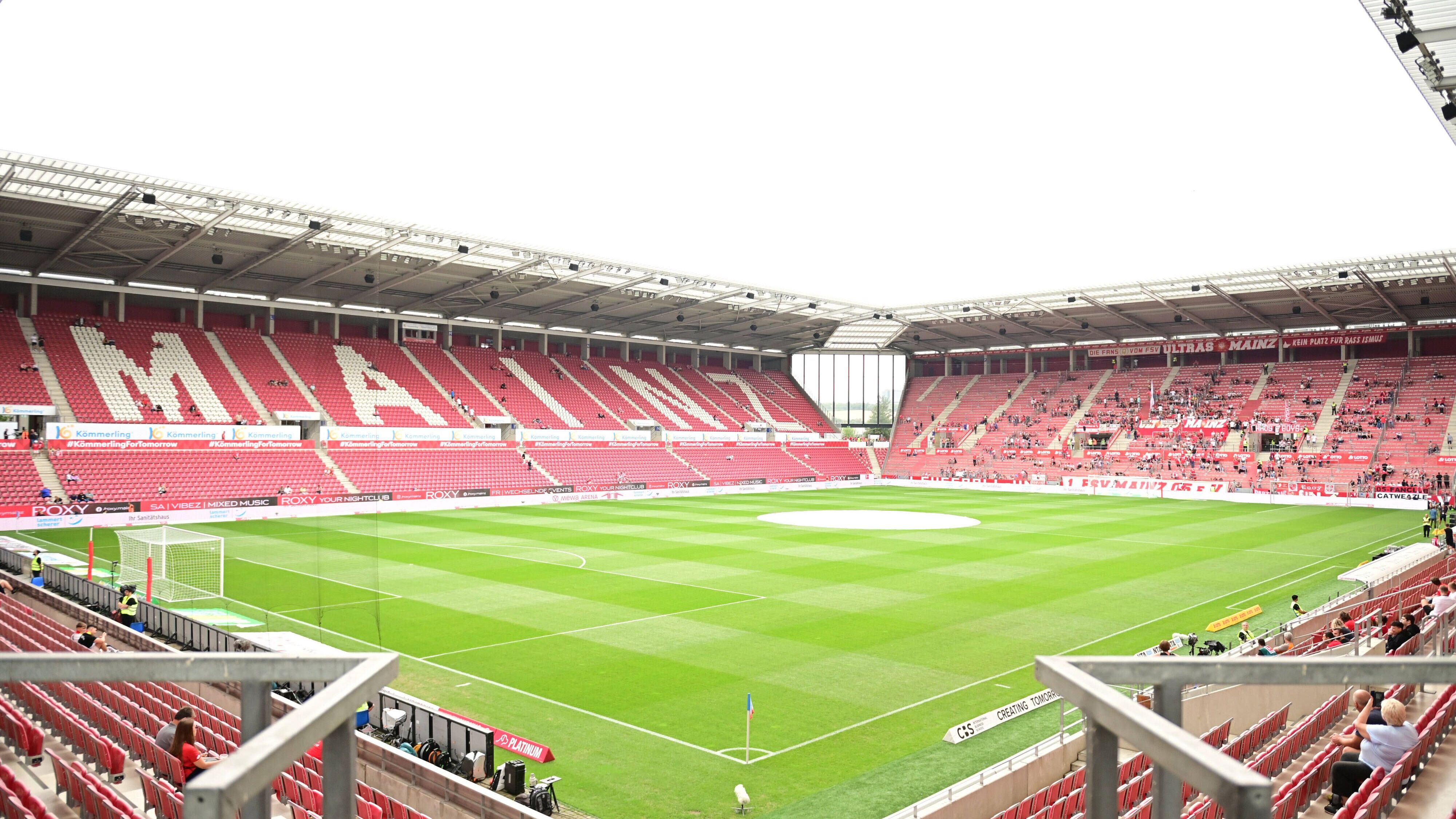 <strong>FSV Mainz 05</strong><br>Nach dem Einstieg eines regionalen Start-ups für Solartechnik firmiert der Klub nun als <strong>"Rheinhessen Future 05"</strong>. Das Bruchweg-Stadion wurde zur "Sonnenkraft-Arena" zurückgebaut – nachhaltig, nostalgisch, laut. Die Fans fordern trotzdem jedes Jahr die Rückkehr von Klopp – auch wenn er längst DFB-Präsident ist.